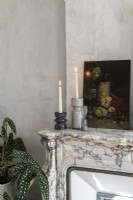 Detail of painting and candles on marble mantelpiece