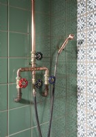 Detail of industrial style taps and pipes in shower cubicle