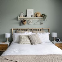 Shelf and hooks above bed with bamboo headboard