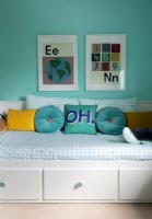 Colourful pictures above day bed in childrens room