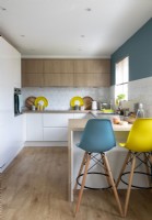Small modern kitchen with blue and yellow barstools 