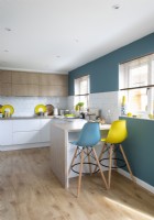 Blue and yellow barstools next to small breakfast bar in kitchen