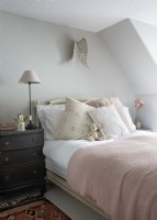 Small teddy bear on bed in country bedroom