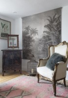 Antique armchair next to large painting in country living room