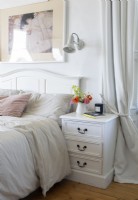 White feminine bedroom - bedside cabinet and flowers