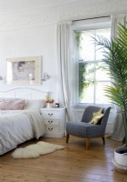 Feminine bedroom with wooden flooring and large house plant