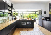 Modern black white and wooden kitchen with view to garden