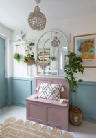 Pink painted bench in blue and white hallway