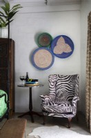 Animal print upholstered armchair and woven basket wall display
