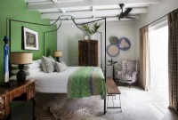 Bedroom with metal four-poster bed and green feature wall