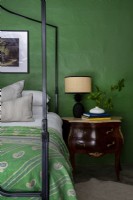 Antique console table in bedroom with green feature wall
