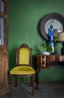Vintage furniture against green feature wall