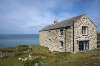 Exterior of old stone barn conversion, formerly a 'fish cellar' on the cliff at Gunwalloe, Cornwall