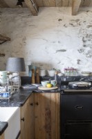 Kitchen worktop with Aga cooker and white washed walls