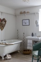 Old-fashioned bathroom with tongue and groove wall and roll top bath