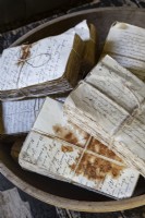 Bundles of old book pages tied with string and stained