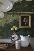 Gilded framed portrait on distressed painted green wall