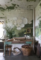 Wooden table in rustic kitchen with distressed painted walls