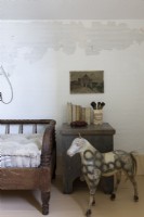 Antique horse sculpture next to daybed in vintage style bedroom