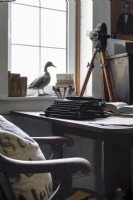 Vintage typewriter on wooden desk with antique ornaments 