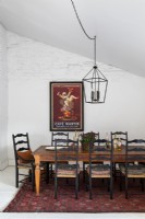 Large framed poster on white wall of country dining room