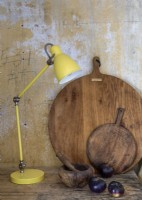 Retro yellow lamp next to chopping boards on kitchen worktop