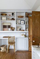Built in white wooden shelving unit and wicker chair