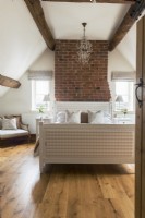 Exposed brickwork and beams in modern country bedroom