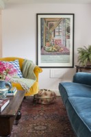 Framed poster on wall of living room with colourful furniture
