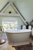 Studded freestanding bath by window in country bathroom