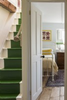Green painted stairs and view to bedroom from landing
