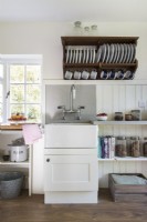 Wall mounted plate rack above butler sink in country kitchen