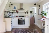 Small oven and extractor in white modern kitchen