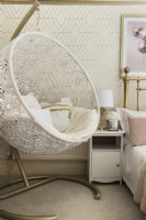 Decorative swing seat in gold and pink themed bedroom
