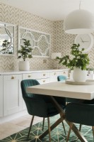 Patterned wall paper and mirrors in modern dining room