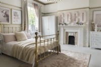 Gold metal framed bed in modern gold and pink bedroom