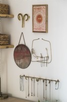 Detail of artwork and jewellery storage - hanging hooks on wall