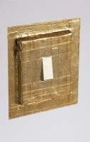 Detail of light switch covered in gold paper