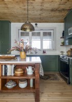 Pendant light over wooden island in country kitchen
