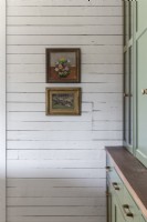 Framed paintings on painted wooden wall