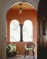 Red stucco entry with black painted door.