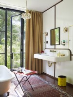 Bathroom with door to outside, clawfoot tub and vintage sink