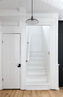 White painted staircase in wooden country hallway