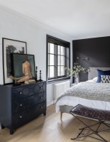 Modern bedroom with black painted feature wall behind bed