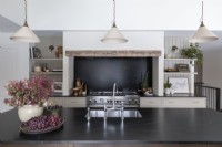 Large range cooker within fireplace in country kitchen