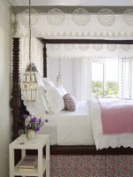 Bedroom with four poster bed and white linens