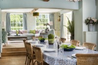 Country dining room laid for a meal with view to living room beyond