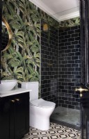Tropical wallpaper and black metro tiles in petite bathroom