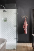 Shower cubicle with white metro tiles in herringbone pattern
