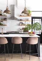 Industrial style pendant lights and velvet stools in black and white kitchen